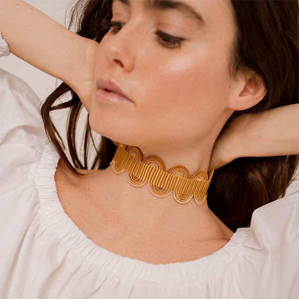 ragazza indossa collana girocollo choker argento nastro passamaneria onde giallo oro made in italy