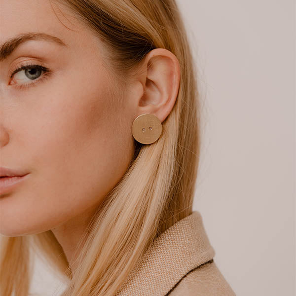 ragazza indossa orecchini oro giallo graffiato bottone made in italy