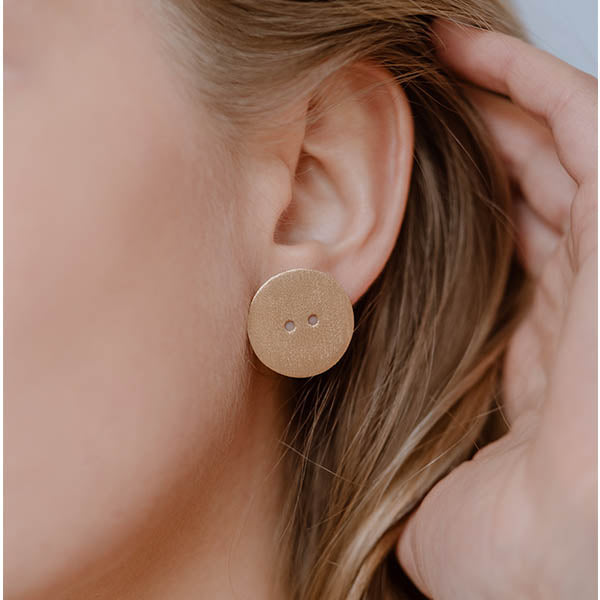 ragazza indossa orecchini oro giallo graffiato bottone made in italy