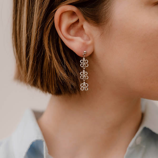 ragazza indossa orecchini pendenti argento tre ghirigori fatti a mano italia