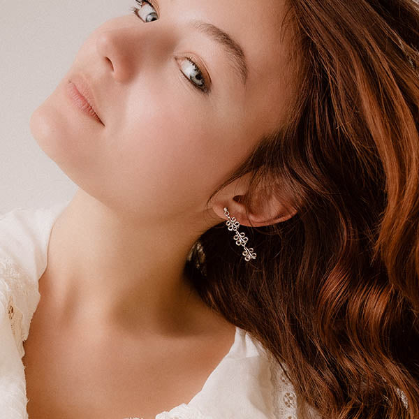 ragazza indossa orecchini pendenti argento tre ghirigori fatti a mano italia