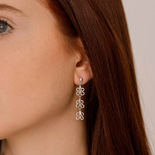 ragazza indossa orecchini pendenti argento tre ghirigori fatti a mano italia